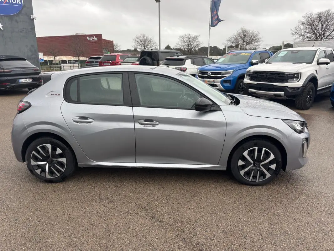 Vue de profil côté gauche d'une Peugeot 208 Hybrid 100 e-DCS6 Style gris 2025 avec jantes 16 pouces et logo Style à l'arrière.