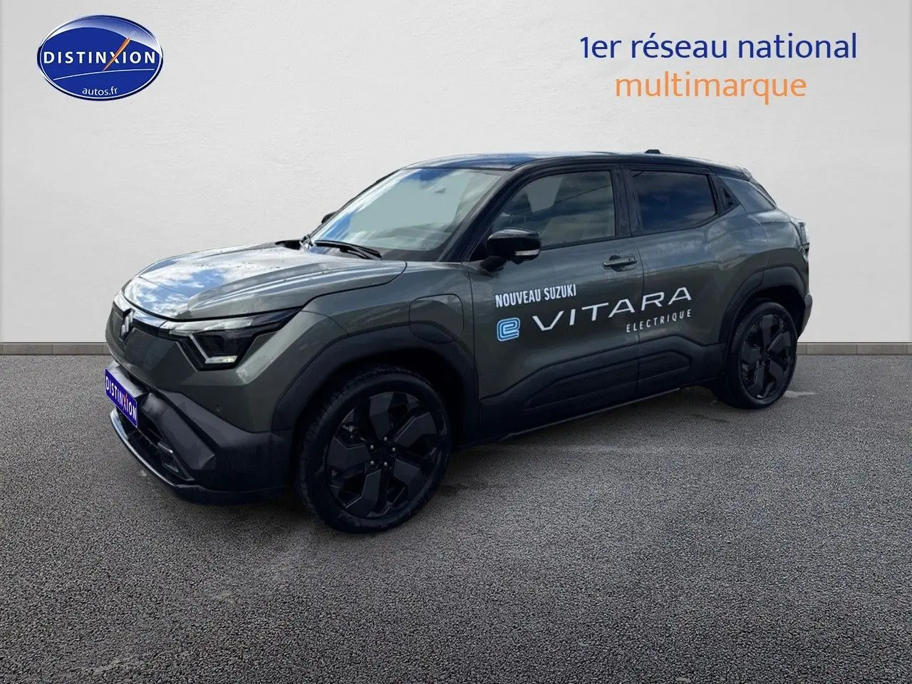 Suzuki Vitara électrique 2026 en 3/4 avant, couleur gris foncé avec toit noir et jantes noires distinctives.