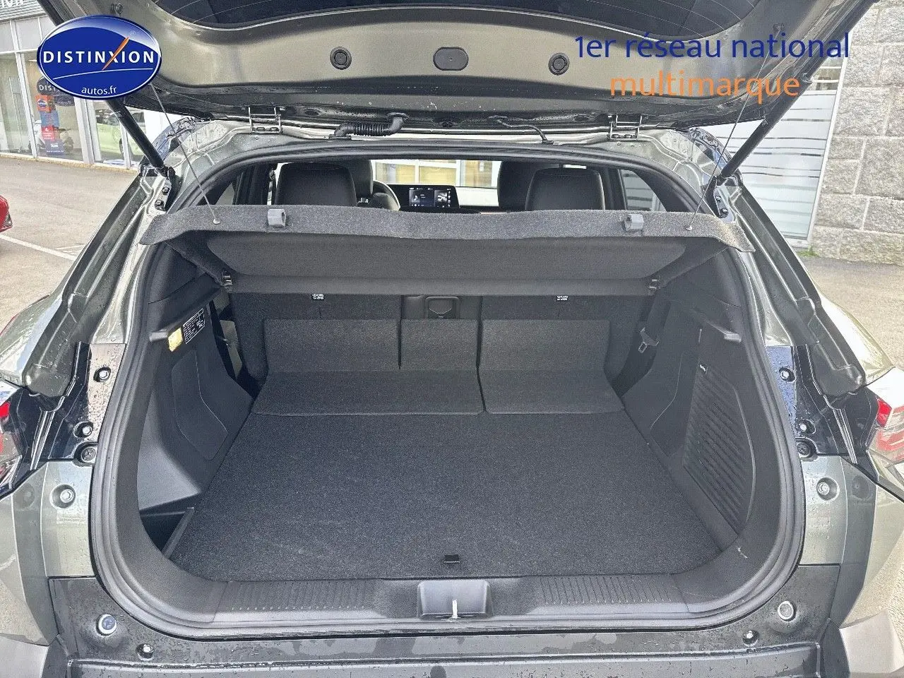 Coffre ouvert vu de l'arrière d'un Suzuki Vitara 2026 vert Land Breeze avec toit noir, intérieur spacieux et banquette rabattue.