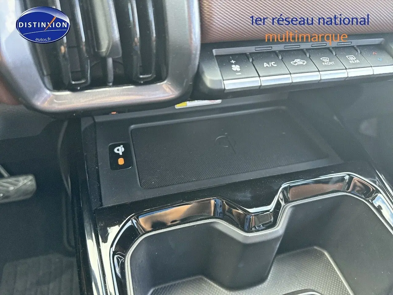 Vue rapprochée de la console centrale du Suzuki Vitara 2026 avec chargeur sans fil et commandes climatisation.