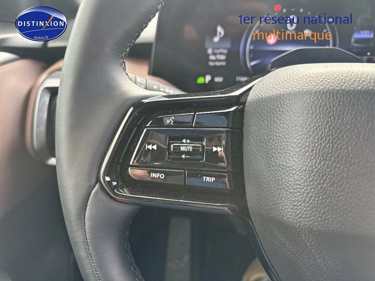 Gros plan sur les commandes du volant noir du Suzuki Vitara 2026, avec boutons multifonctions et affichage numérique en arrière-plan.