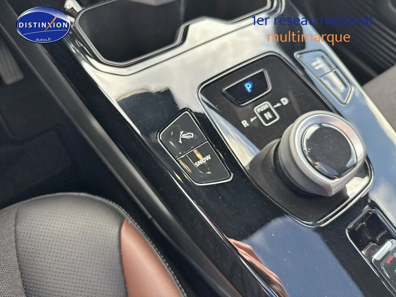 Gros plan sur la console centrale noire brillante du Suzuki Vitara 2026 avec molette de boîte auto et bouton mode Snow.