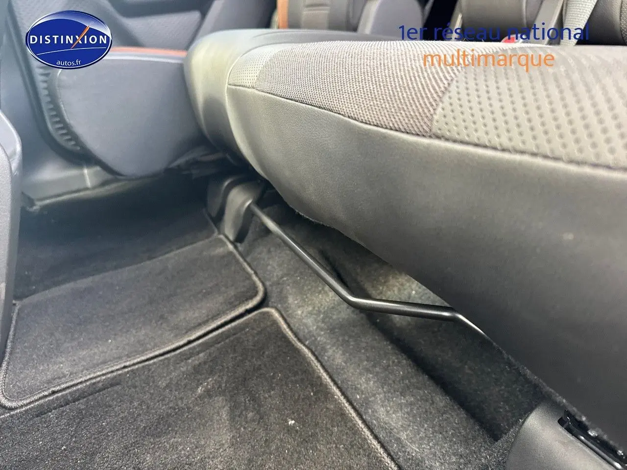 Vue rapprochée sous le siège avant droit du Suzuki Vitara 2026, tissu noir et marron avec moquette noire.