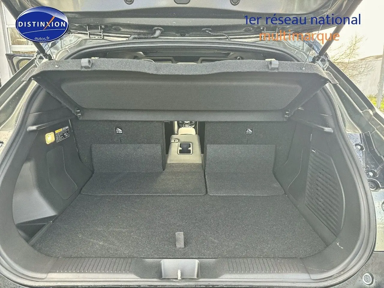 Coffre ouvert du Suzuki Vitara 2026 vert Land Breeze avec toit noir, vue arrière montrant banquette rabattue et espace de chargement.