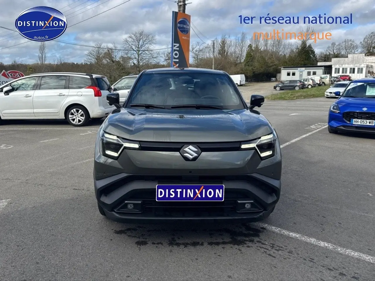 Vue avant d'un Suzuki Vitara 2026 vert foncé avec toit noir, éclairage LED et calandre épurée sur parking.