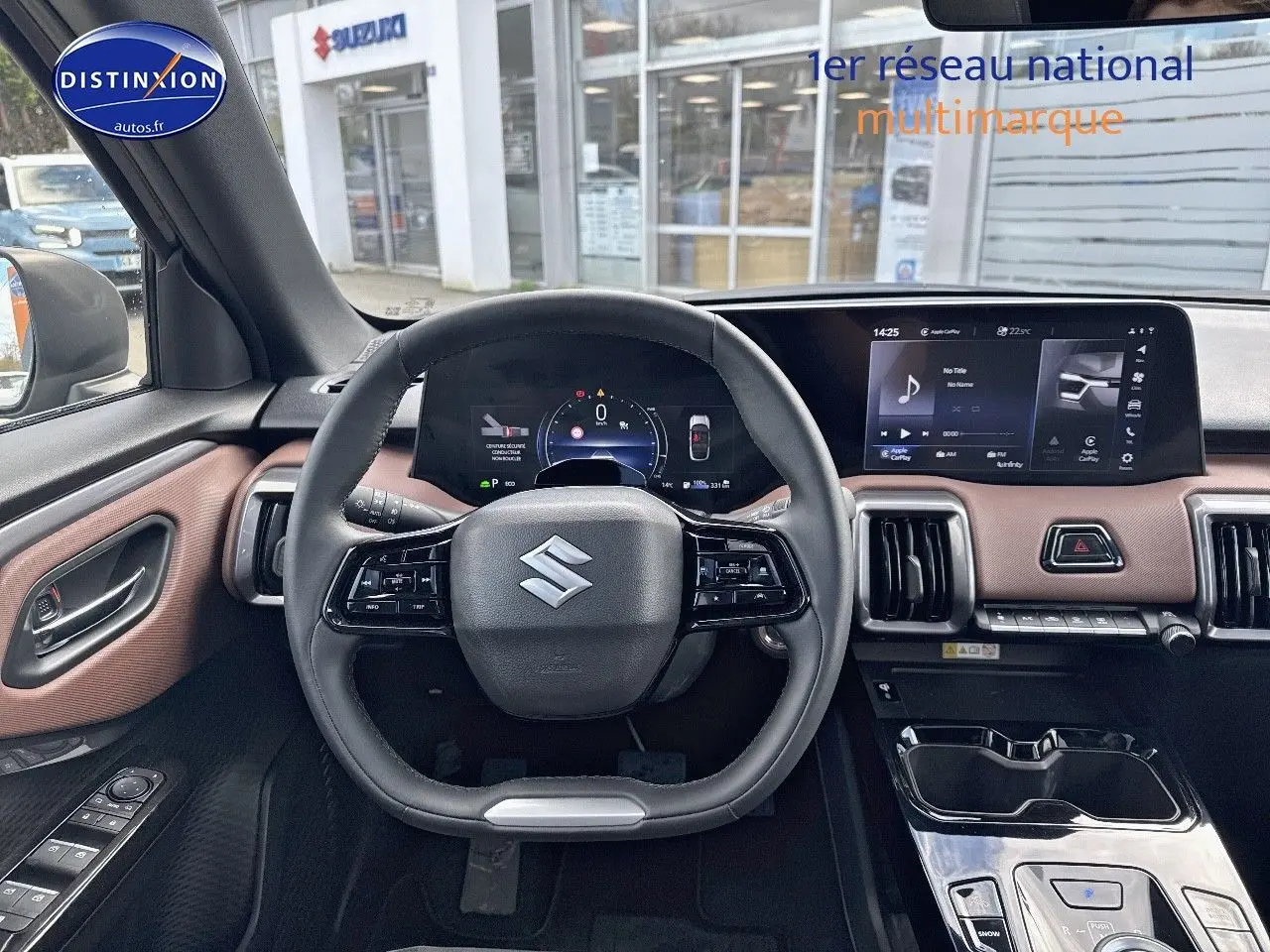 Vue intérieure centrée sur le volant et le tableau de bord du Suzuki Vitara 2026 avec écran tactile et garniture marron.