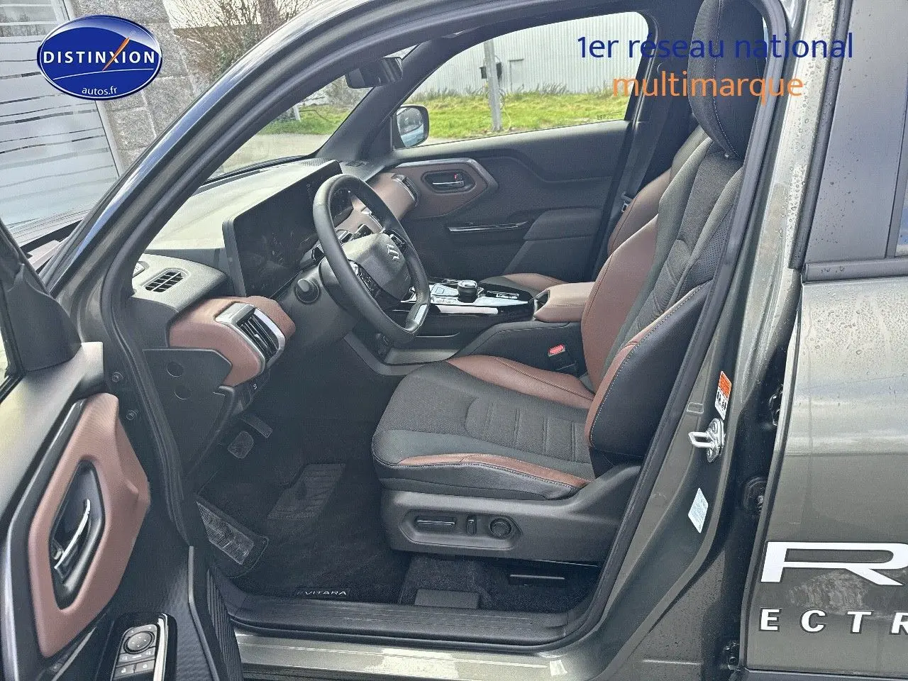 Vue côté conducteur intérieur du Suzuki Vitara 2026 vert Land Breeze avec sellerie tissu/cuir marron et noir.