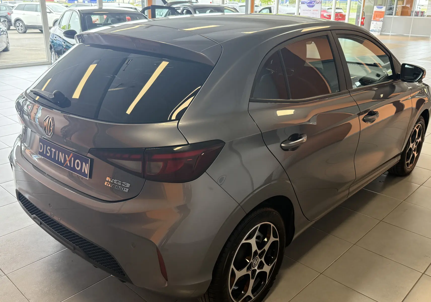 Vue 3/4 arrière droite d'une MG3 Hybrid+ gris métallisé Hampstead avec vitres surteintées et jantes alliage 16 pouces.