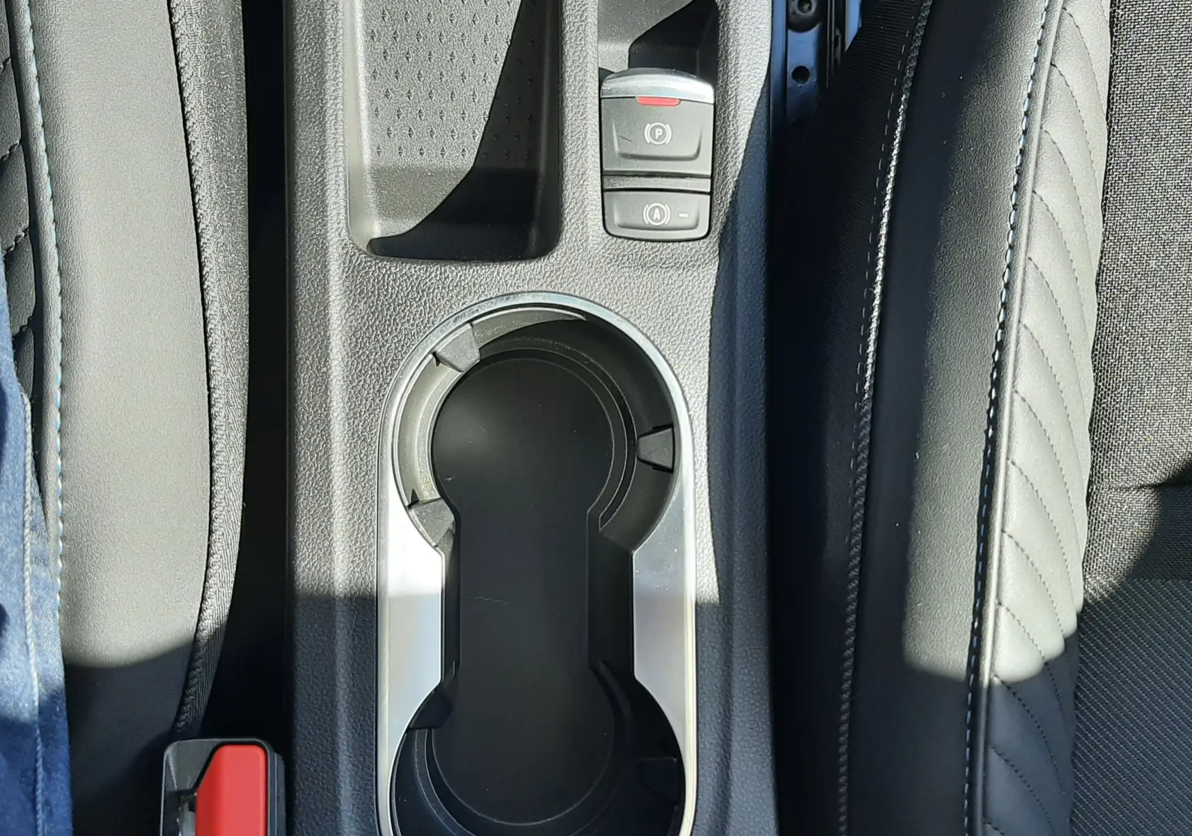 Gros plan sur la console centrale du Renault Symbioz gris Rafale, montrant porte-gobelets et commandes électroniques.