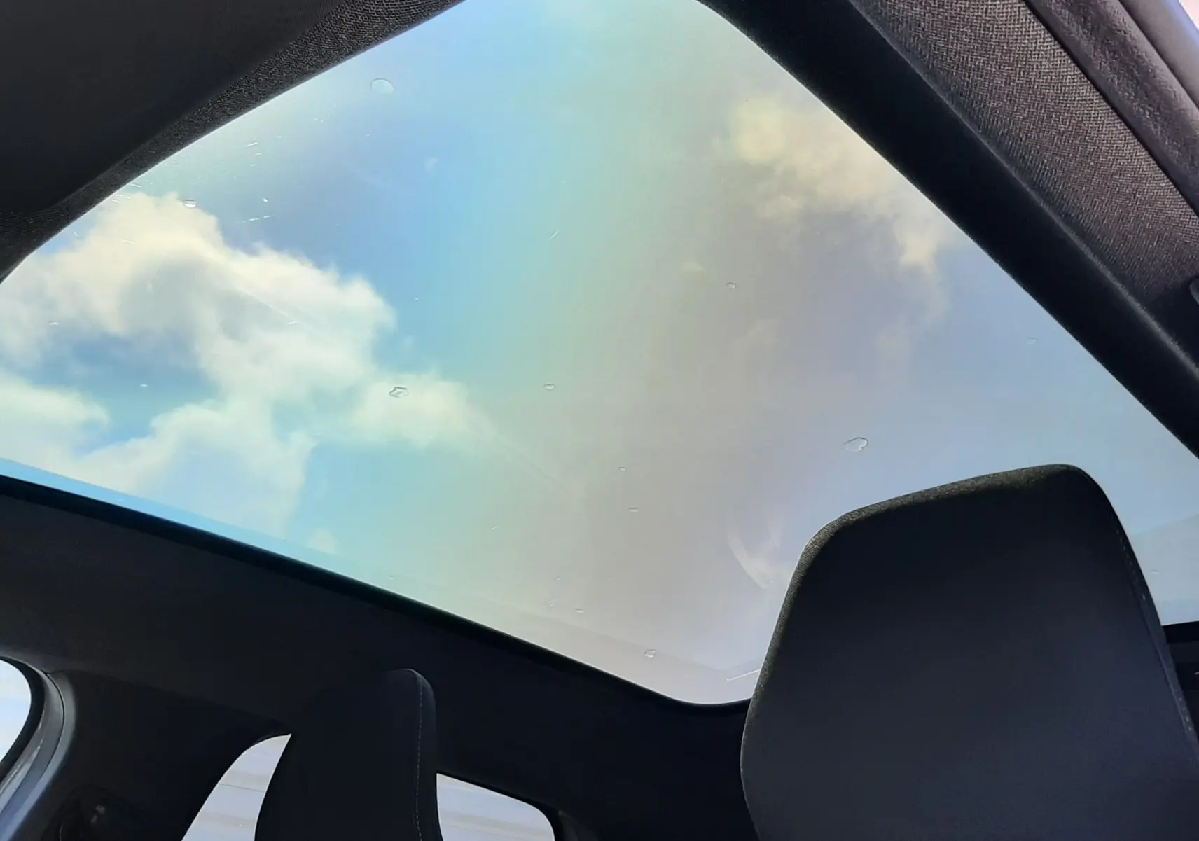 Vue intérieure du toit panoramique du Renault Symbioz gris Rafale 2025, avec ciel visible à travers la large vitre.