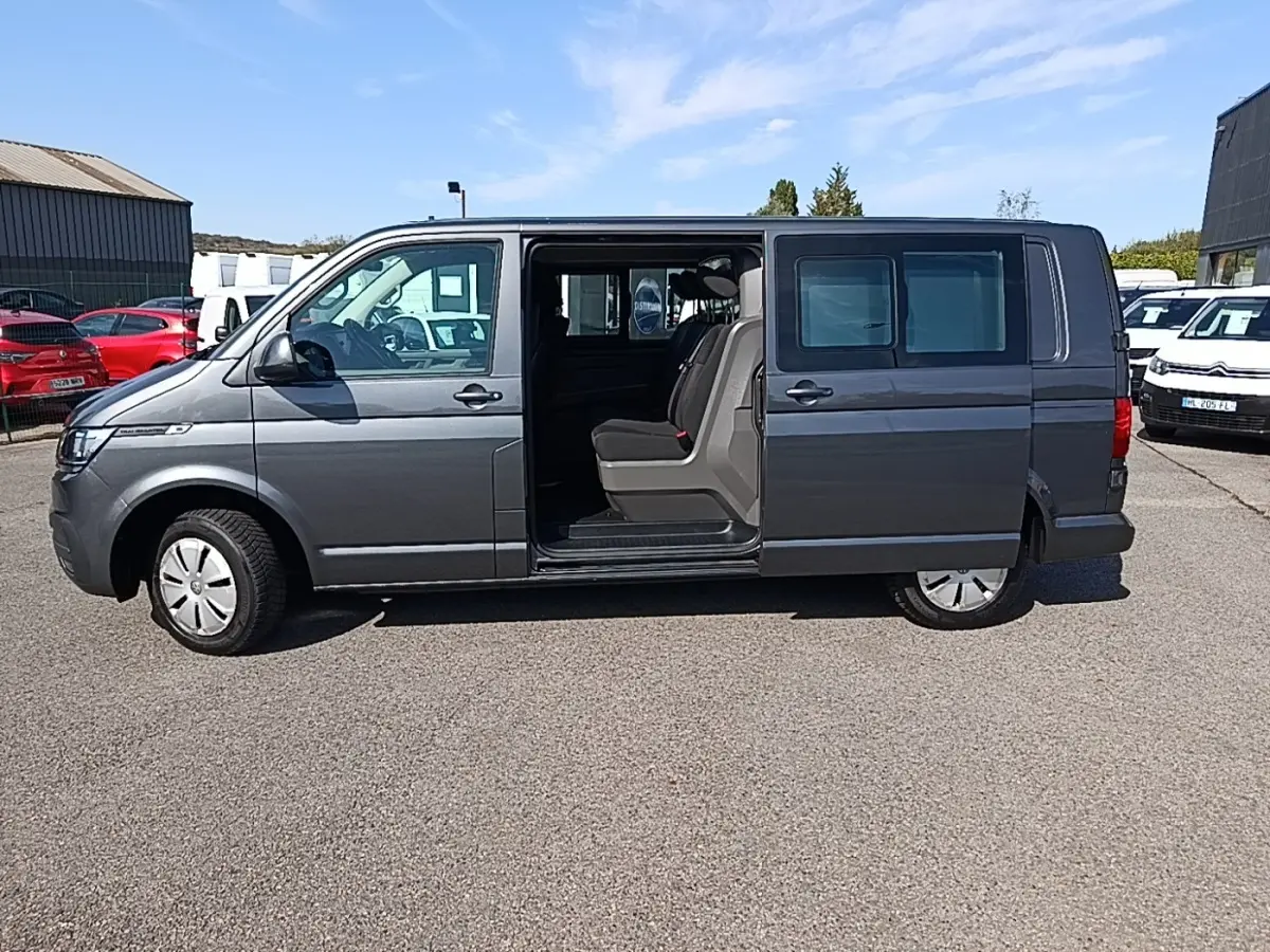 Vue latérale droite d’un Volkswagen Transporter gris foncé 2022 avec porte coulissante ouverte montrant les sièges arrière.