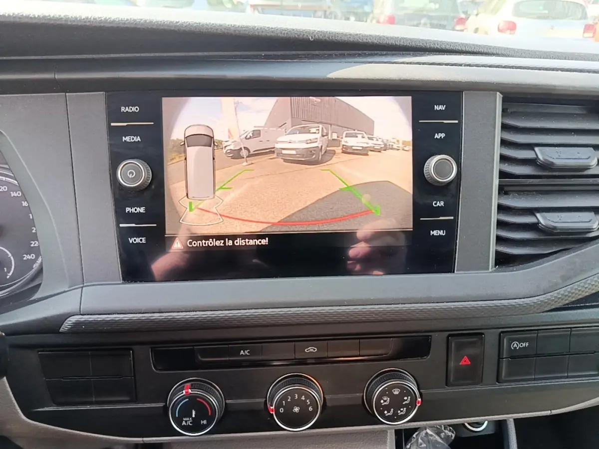 Vue intérieure du tableau de bord du Volkswagen Transporter gris foncé, avec écran tactile affichant la caméra de recul.