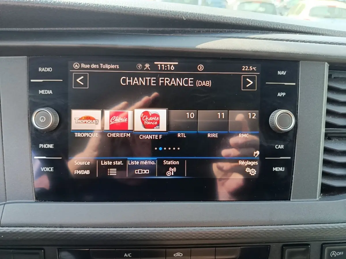 Écran tactile central du tableau de bord du Volkswagen Transporter gris foncé, affichant la radio numérique.