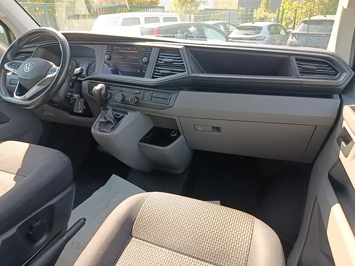 Vue intérieure côté conducteur du tableau de bord gris clair et volant cuir multifonctions du Volkswagen Transporter 2022.