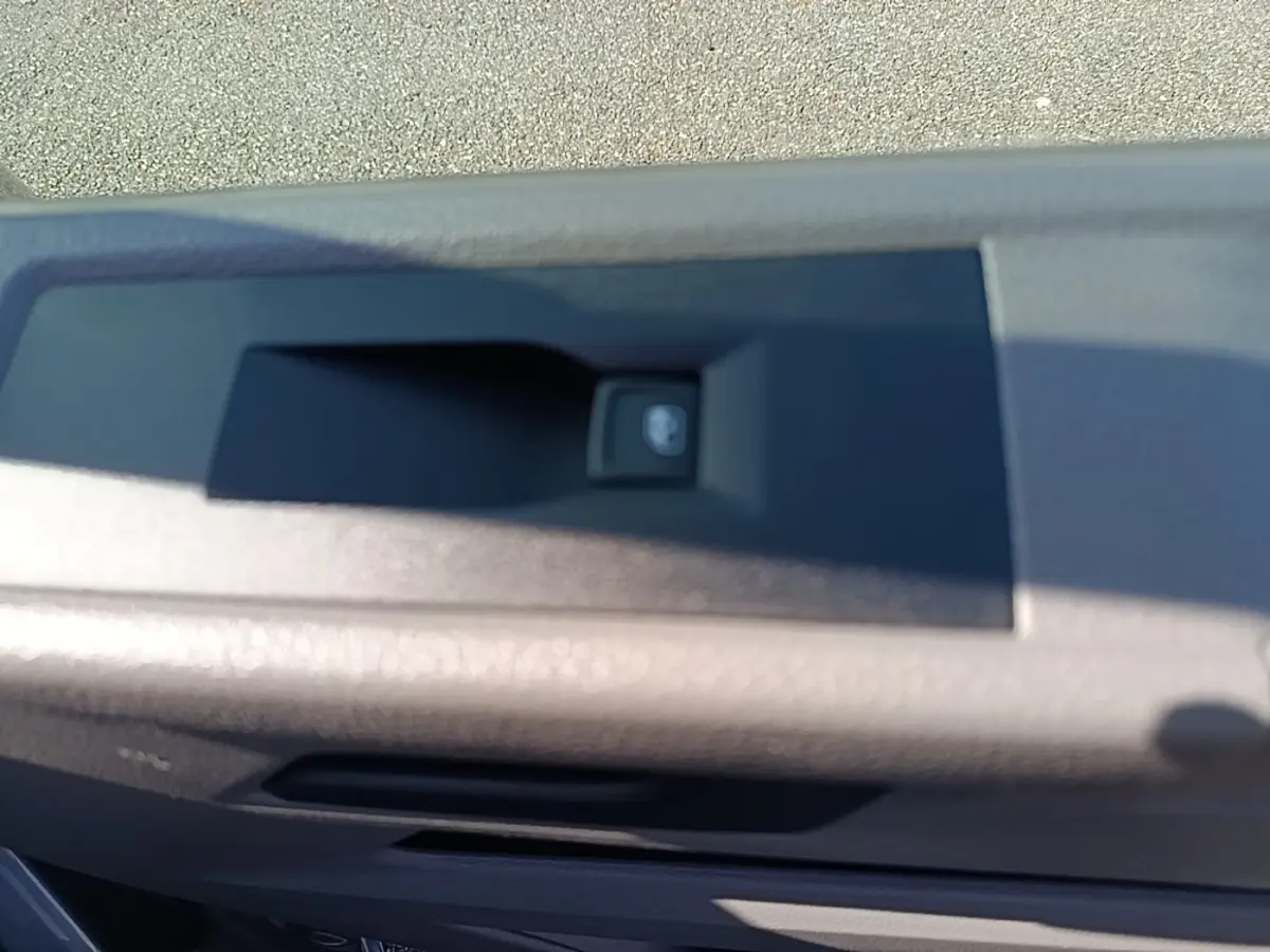 Gros plan sur le bouton de verrouillage centralisé sur la porte intérieure du Volkswagen Transporter gris foncé.