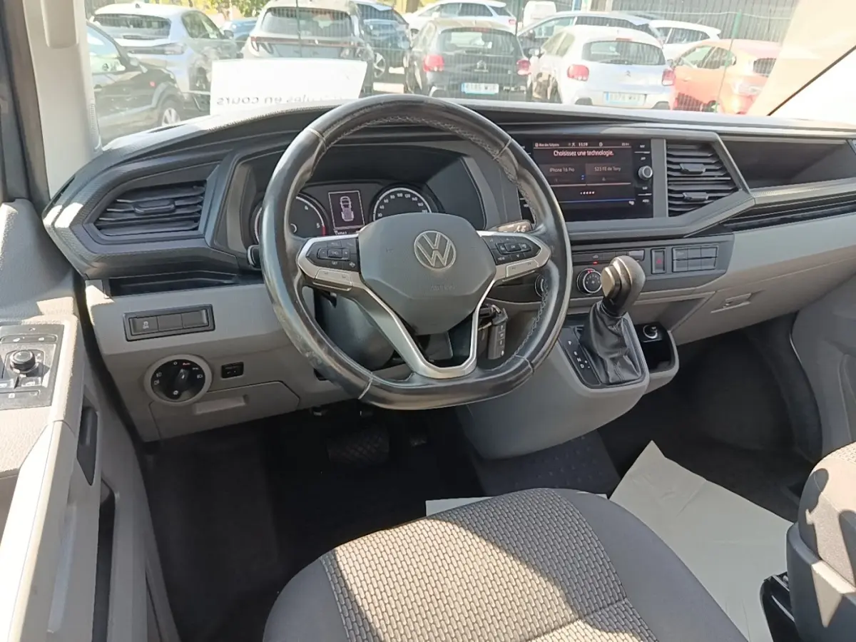 Vue intérieure du tableau de bord et volant cuir multifonctions d’un Volkswagen Transporter gris foncé de 2022.