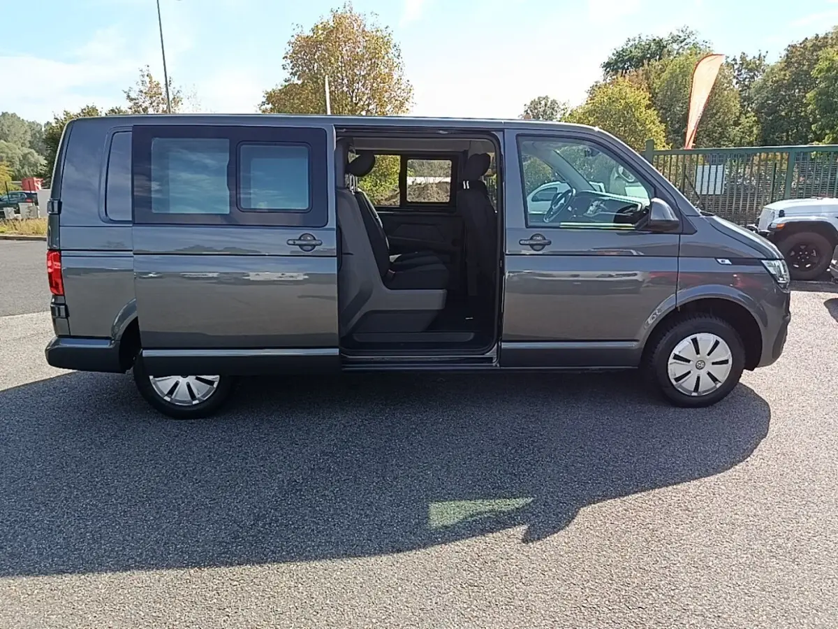 Vue latérale droite d'un Volkswagen Transporter gris foncé 2022 avec porte coulissante ouverte montrant l'intérieur.