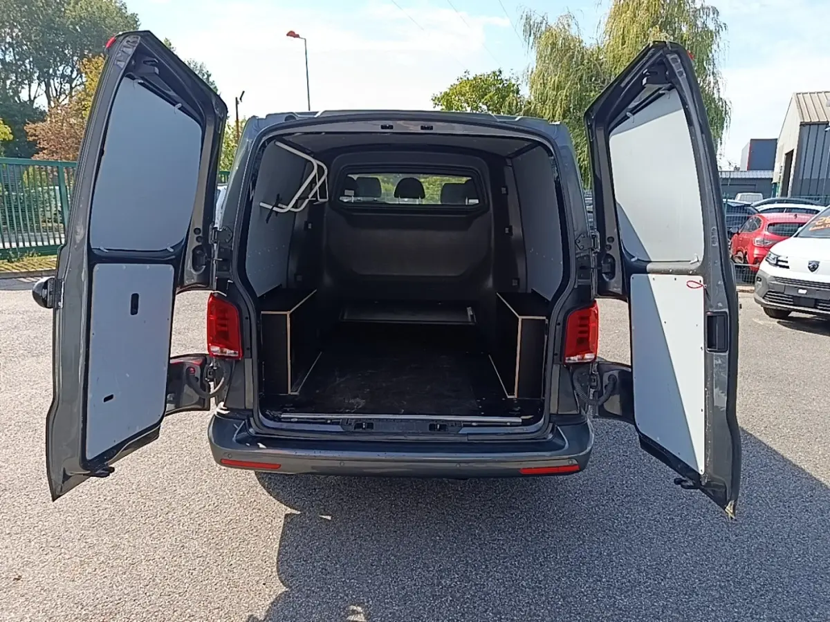 Vue arrière du Volkswagen Transporter gris foncé 2022 avec portes battantes ouvertes montrant l'espace de chargement vide.
