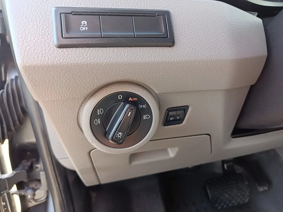 Gros plan sur le tableau de bord beige du Volkswagen Transporter 2022, avec commande des phares et pédale visible.