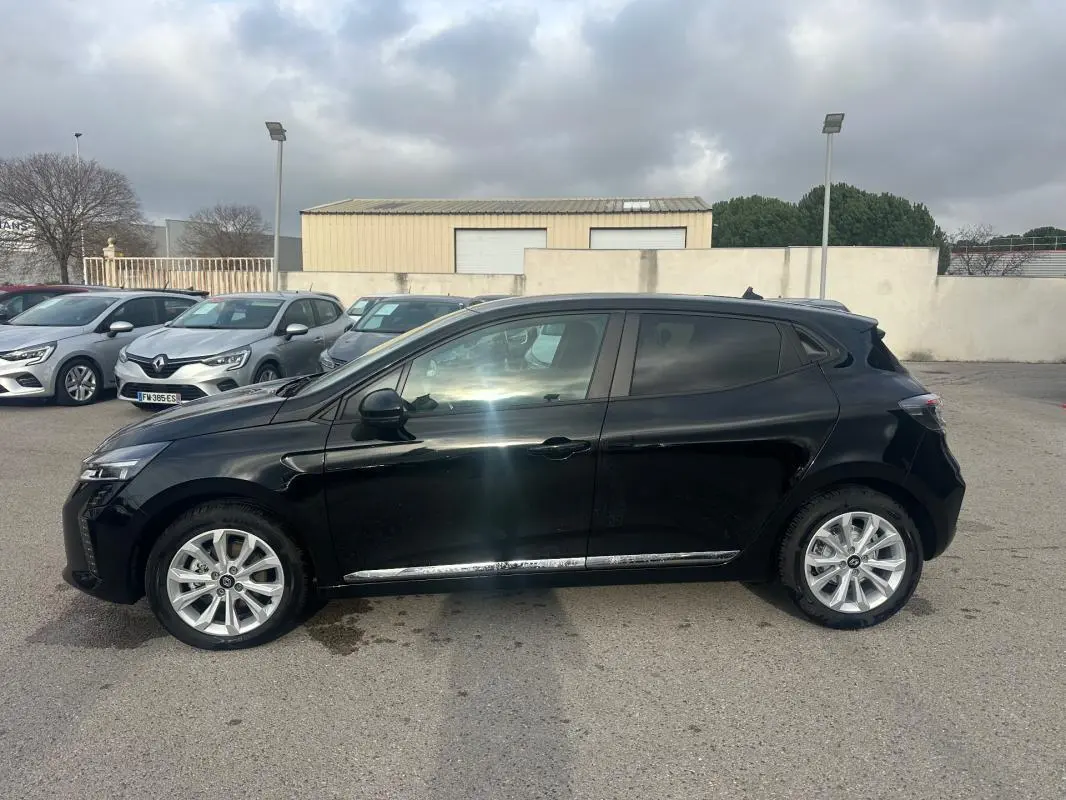 Renault Clio V dCi 100 Evolution noire vue de profil côté gauche, vitres surteintées et jantes argentées visibles.