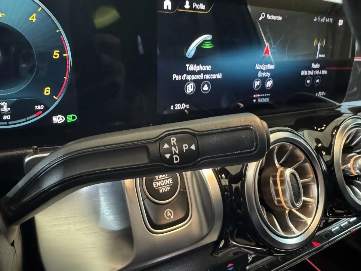 Gros plan sur la commande de boîte automatique et le tableau de bord numérique du Mercedes GLB 200 d AMG Line noir.