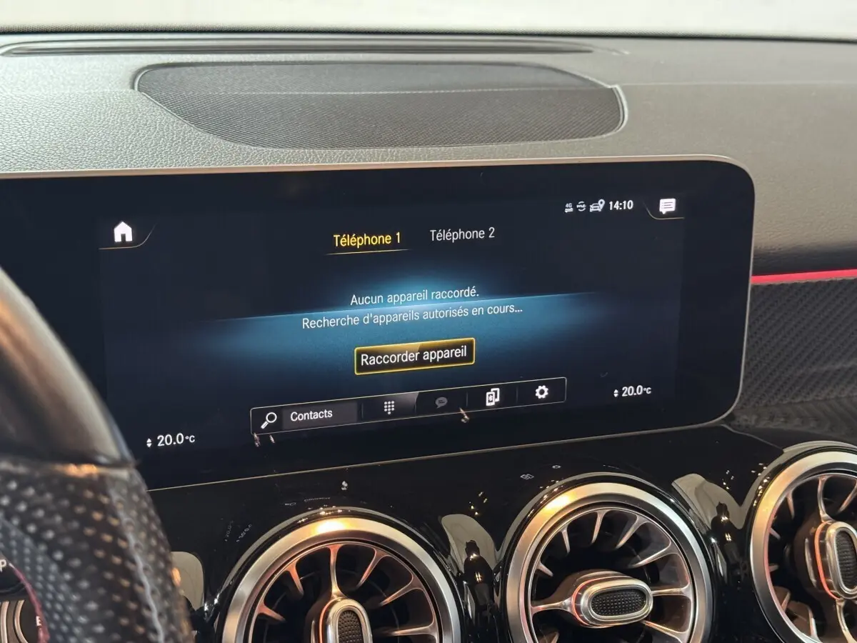 Vue rapprochée de l’écran tactile central et des aérateurs ronds noirs du tableau de bord du Mercedes GLB 200 d AMG Line noir.