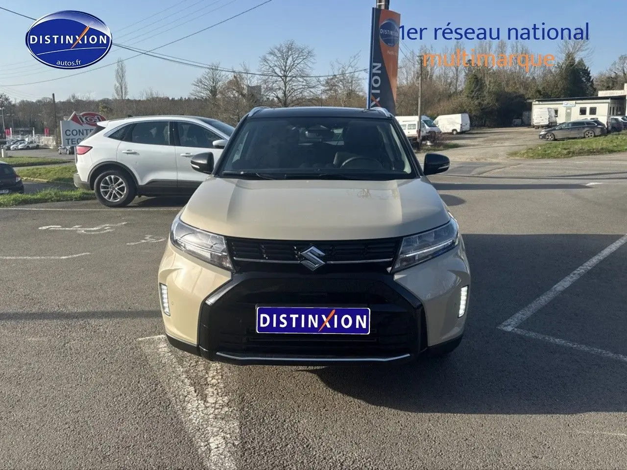Suzuki Vitara 2026 beige So'Color Savanna Ivory vue de face avec calandre noire et feux LED allumés.