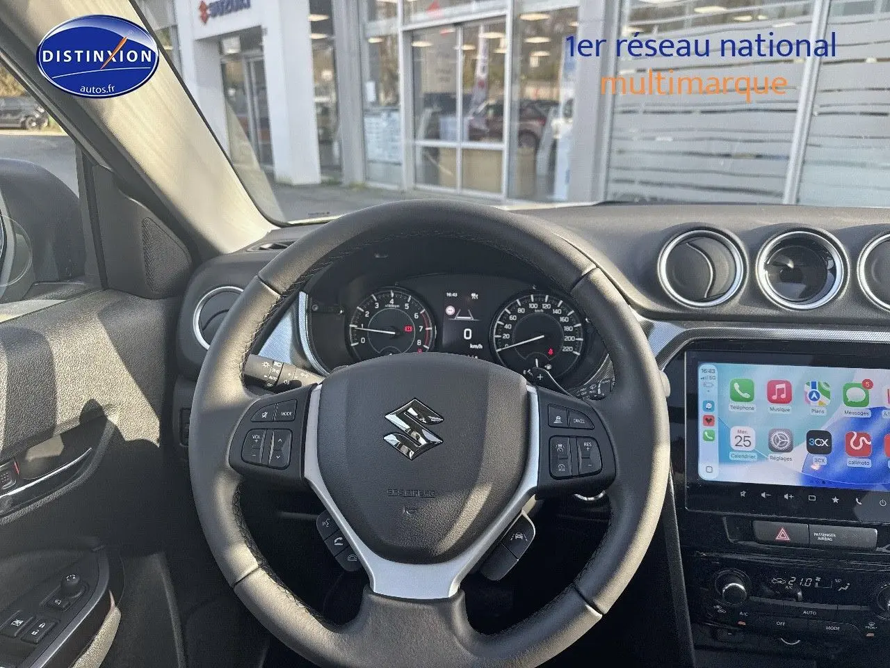 Vue intérieure centrée sur le volant cuir multifonction noir du Suzuki Vitara avec tableau de bord et écran tactile.