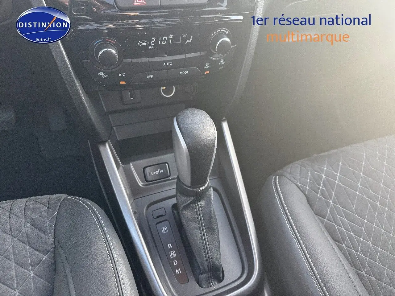 Vue rapprochée de la console centrale du Suzuki Vitara 2026, levier de vitesse automatique et sièges en suédine noire.