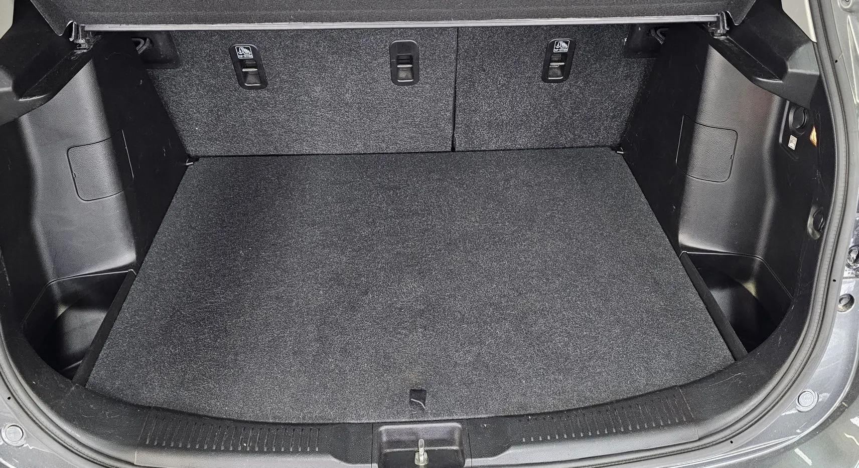 Coffre ouvert du Suzuki SX4 S-Cross gris 2020, vue intérieure montrant un espace de chargement propre et bien fini.