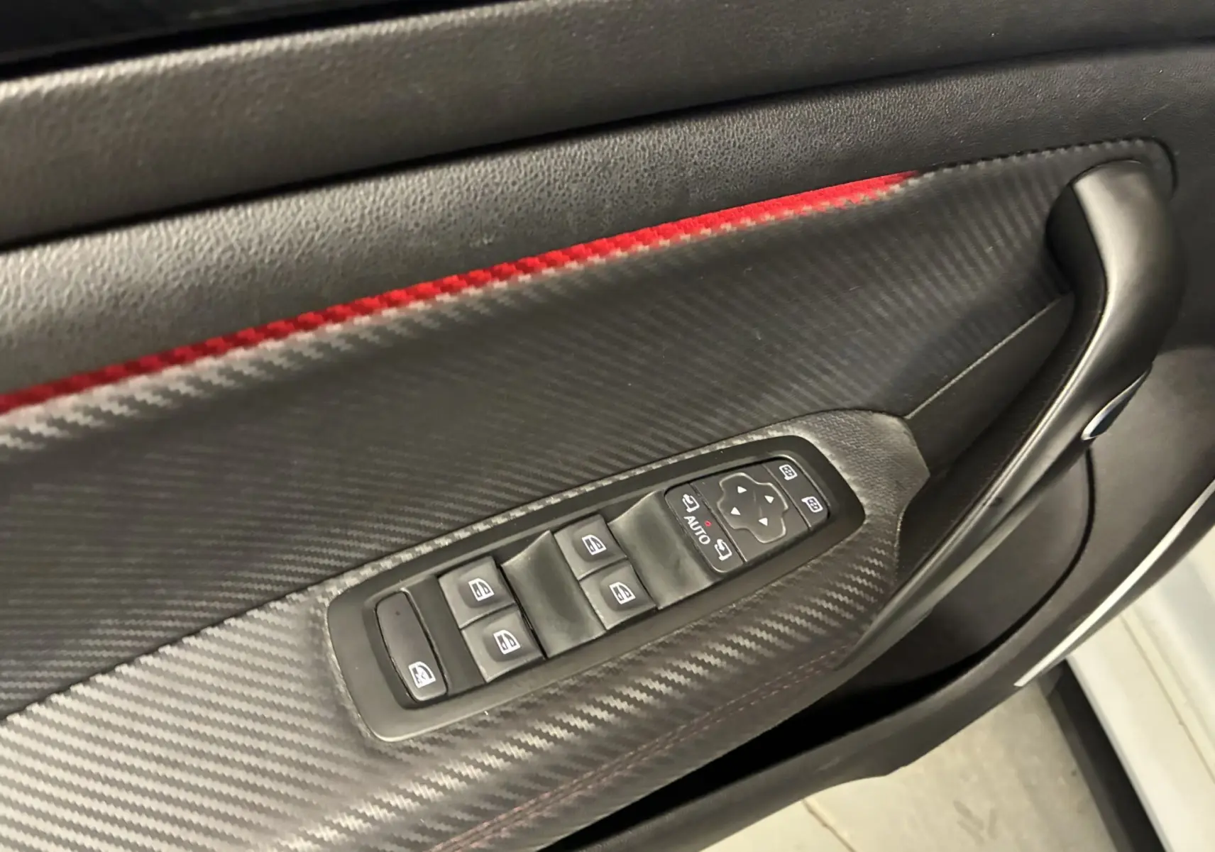 Gros plan sur la roue arrière droite noire brillante avec jante Renault Sport d'une Renault Mégane IV RS 280 blanche.