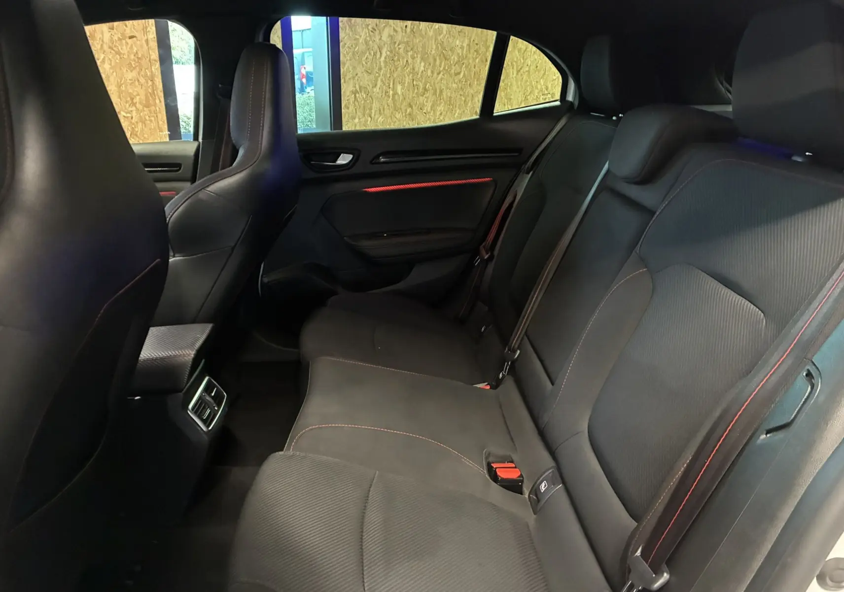 Vue intérieure côté conducteur de la Renault Mégane IV RS 280 EDC6 avec volant sport noir et détails rouges.