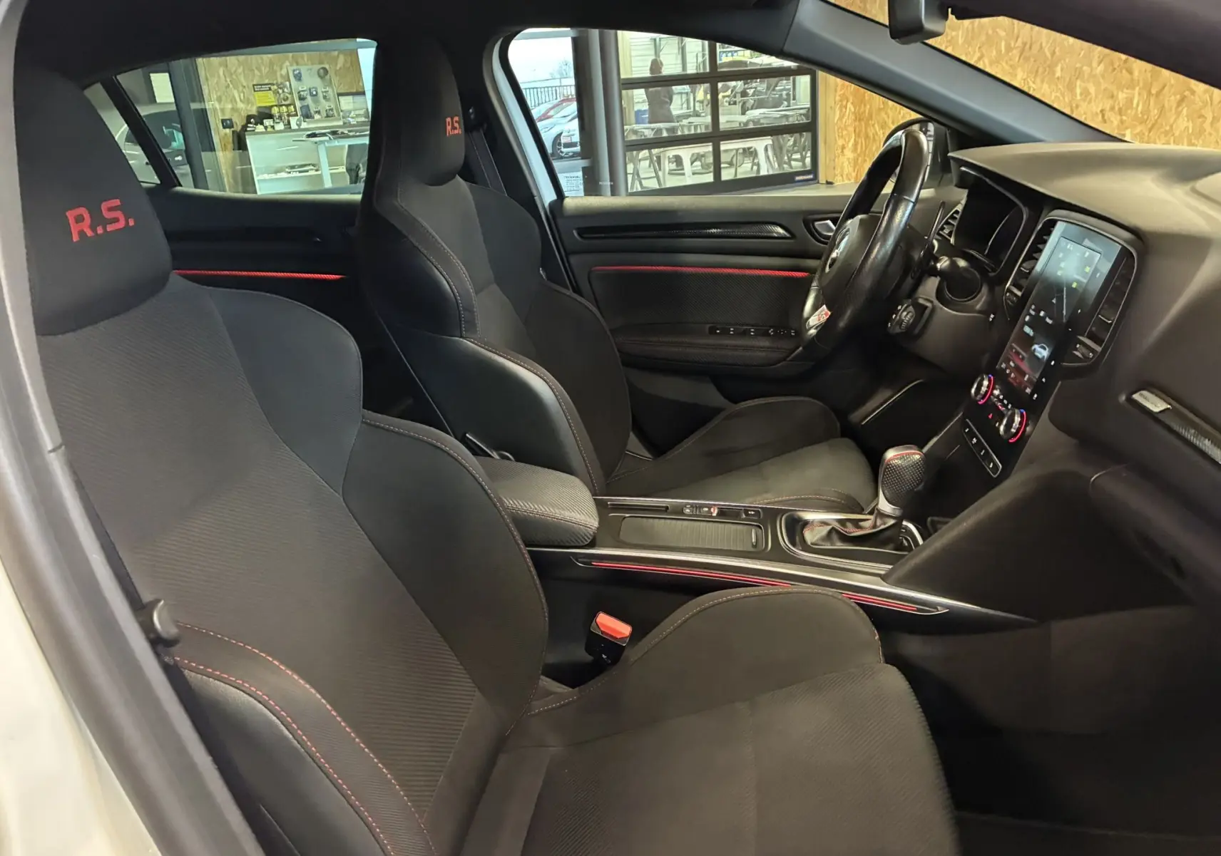 Vue intérieure du siège arrière droit de la Renault Mégane IV RS 280 EDC6 avec sellerie noire et surpiqûres rouges.