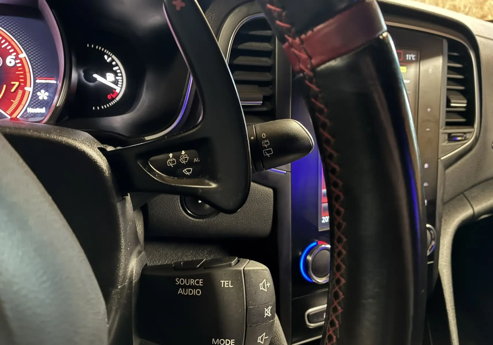 Vue intérieure centrée sur le volant noir R.S. et l'écran tactile du tableau de bord de la Renault Mégane IV RS 280.