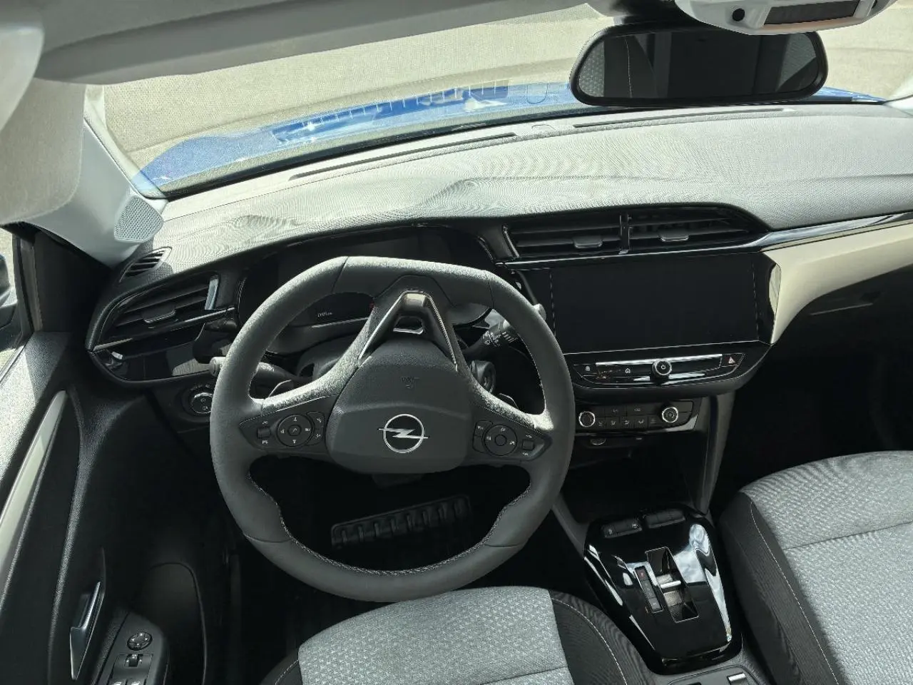 Vue intérieure de l’Opel Corsa 2025 gris kristall, tableau de bord et volant multifonction en premier plan.