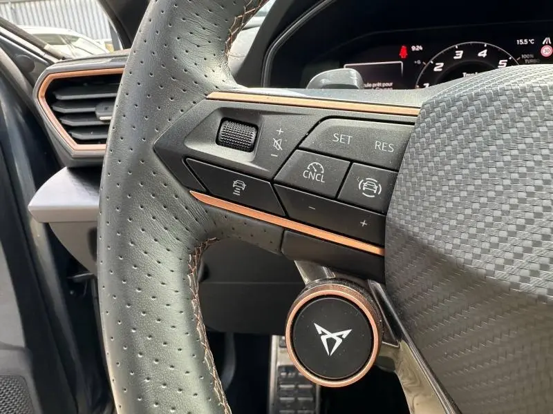 Gros plan sur le volant cuir perforé gris avec commandes multifonctions et logo CUPRA du Formentor 1.5 eTSI Hybrid 2025.