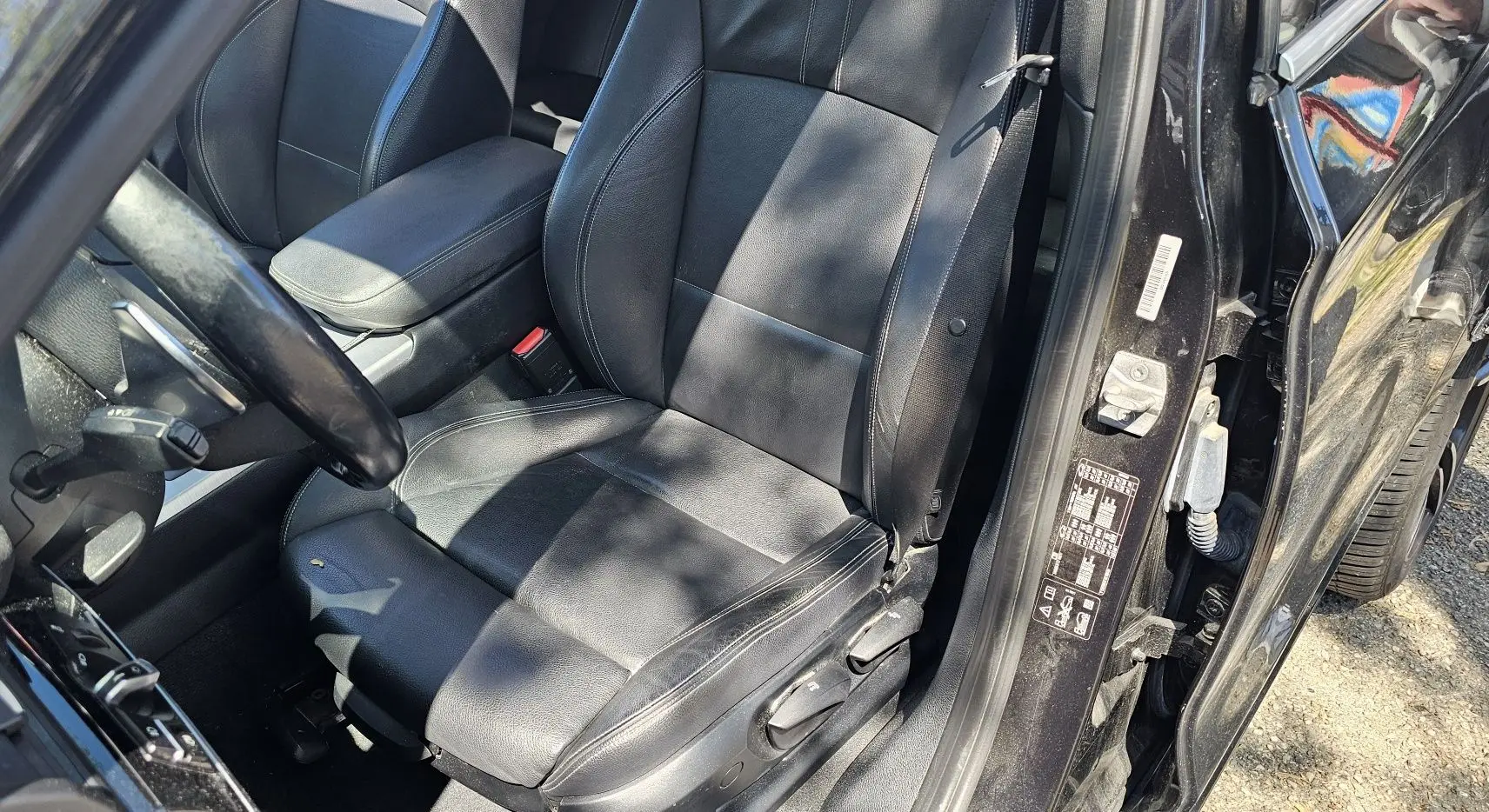 Siège conducteur en cuir noir de BMW X4 xDrive20dA 190ch M Sport 2015, vue intérieure côté gauche avec portière ouverte.