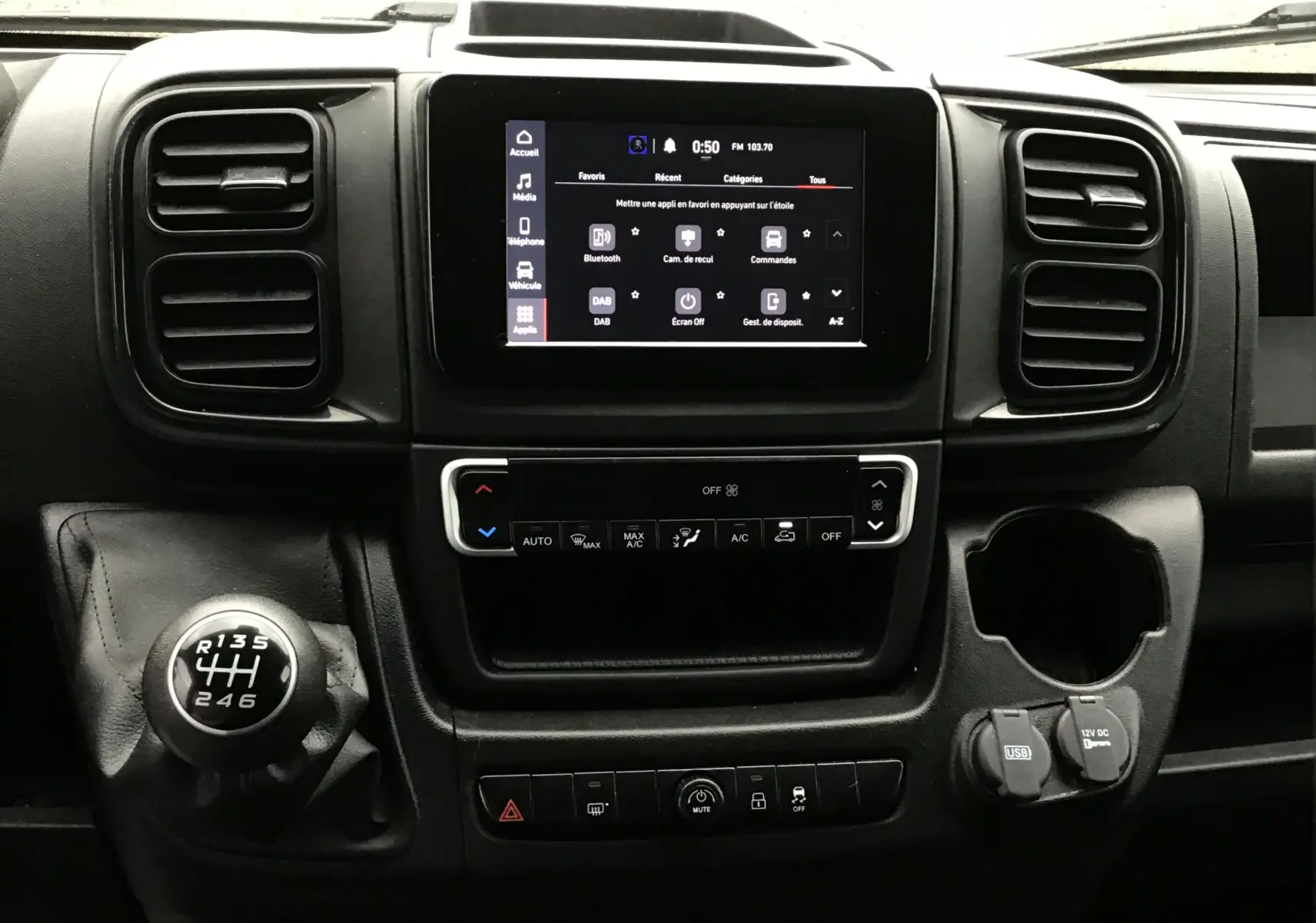 Vue rapprochée du tableau de bord du Fiat Ducato Fourgon blanc 2024, mettant en valeur l'écran tactile et le levier de vitesses manuel.