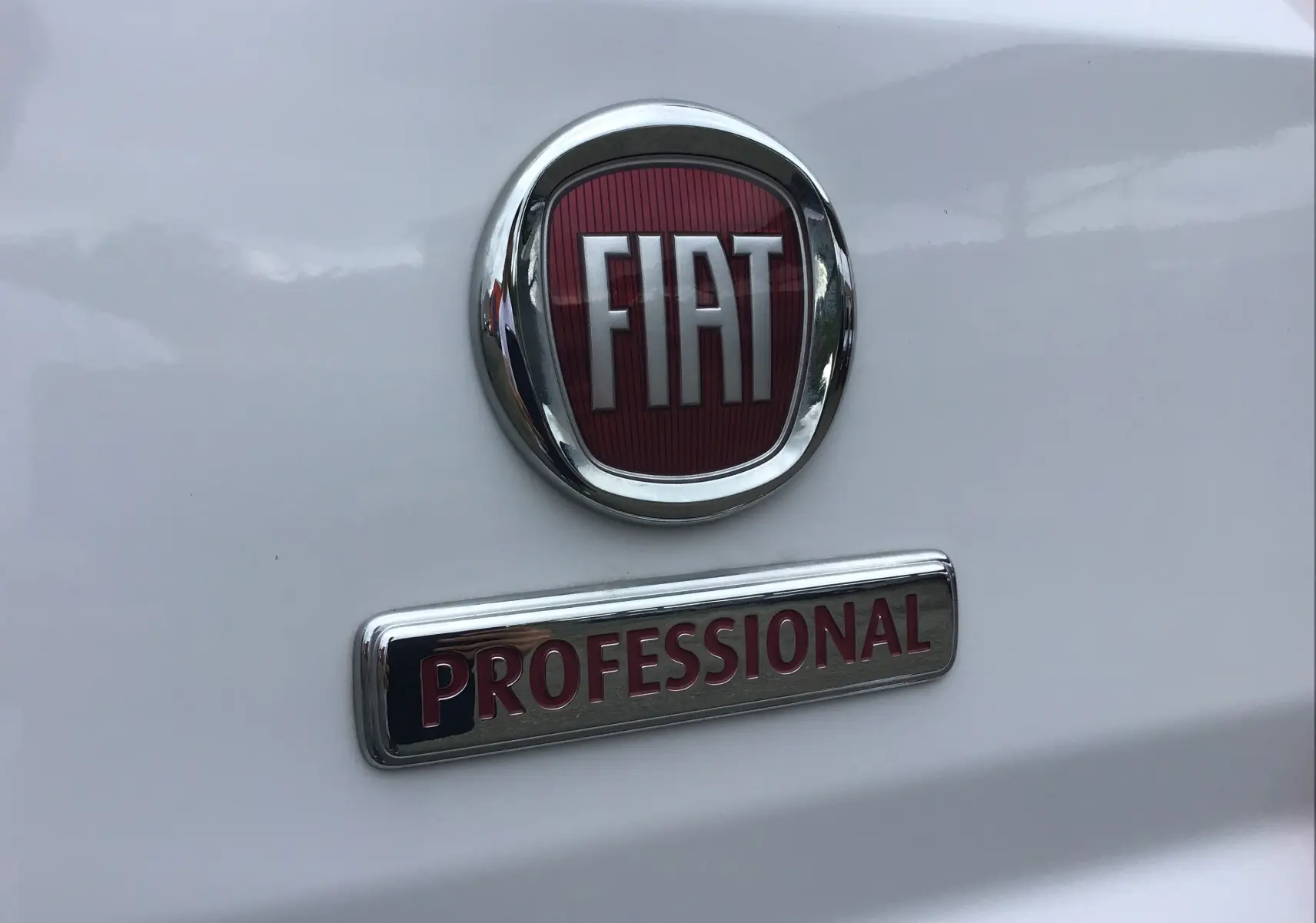 Gros plan sur l'arrière blanc du Fiat Ducato Fourgon avec le logo rouge FIAT et l'inscription Professional chrome.