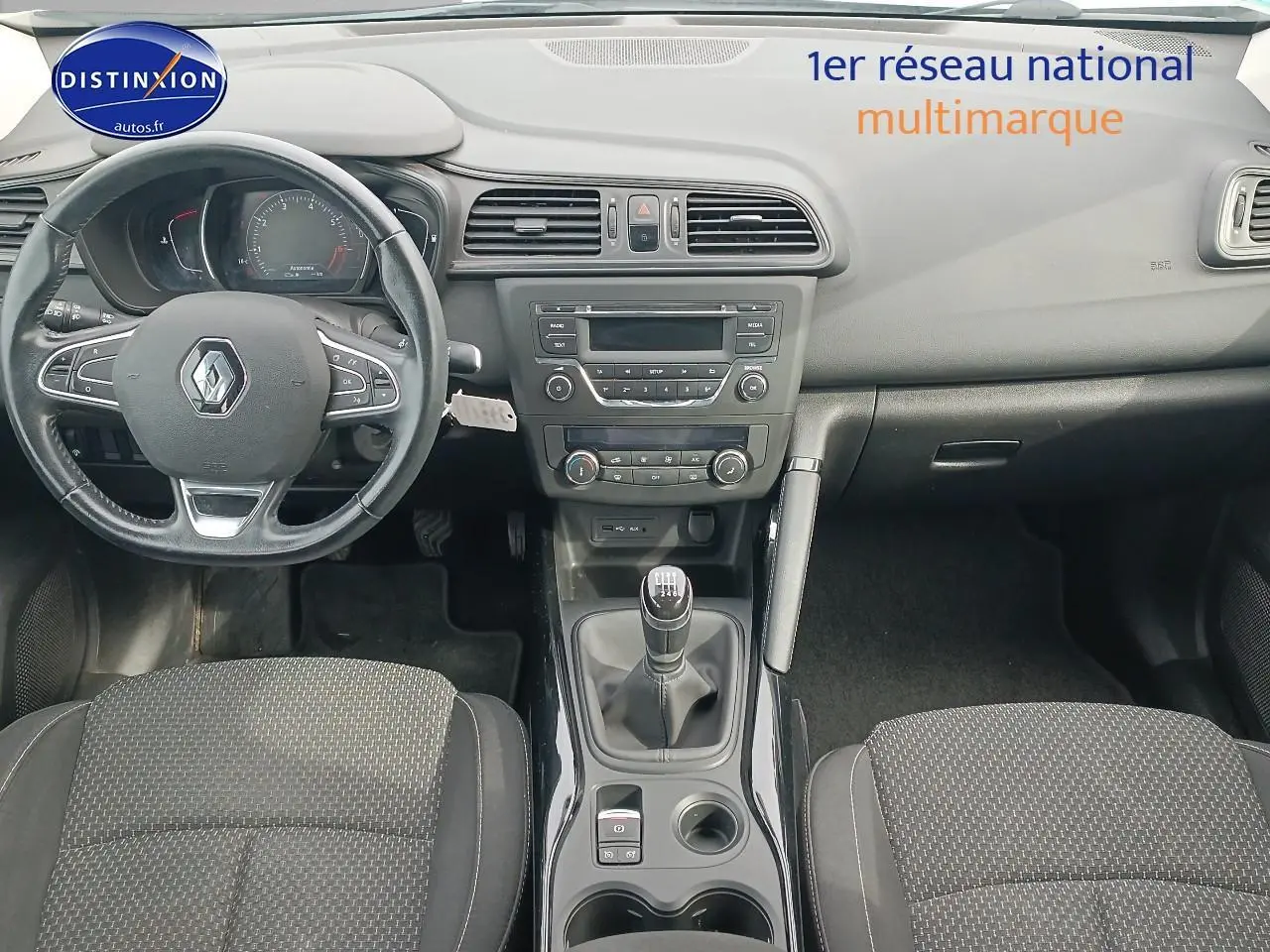 Vue intérieure du tableau de bord et console centrale du Renault Kadjar 1.2 TCe 130 Life avec volant cuir et levier de vitesse manuel.