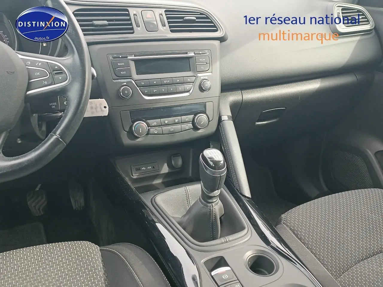 Intérieur Renault Kadjar 1.2 TCe 130 Life 2017, vue centrale sur console avec levier de vitesses manuel cuir et tableau de bord gris.