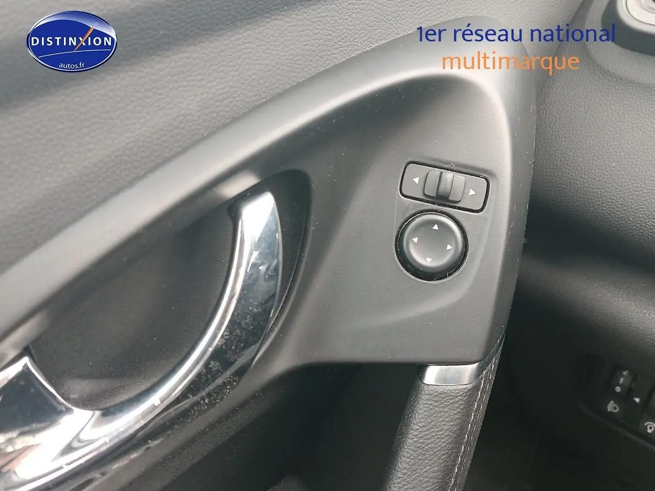 Gros plan sur la poignée de porte intérieure côté gauche du Renault Kadjar gris avec commandes de réglage des rétroviseurs.