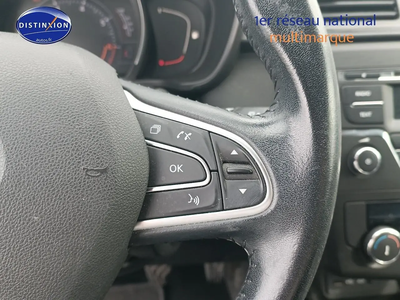 Gros plan sur le volant cuir multifonction du Renault Kadjar gris, avec commandes vocales et audio visibles.