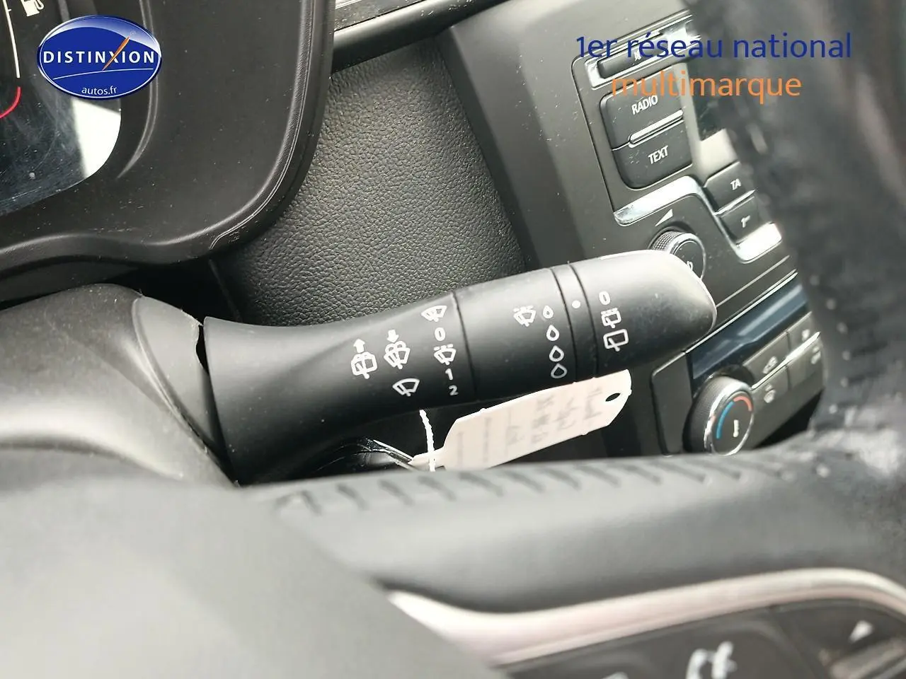 Gros plan sur la manette d'essuie-glace noire et le tableau de bord gris foncé du Renault Kadjar 2017.