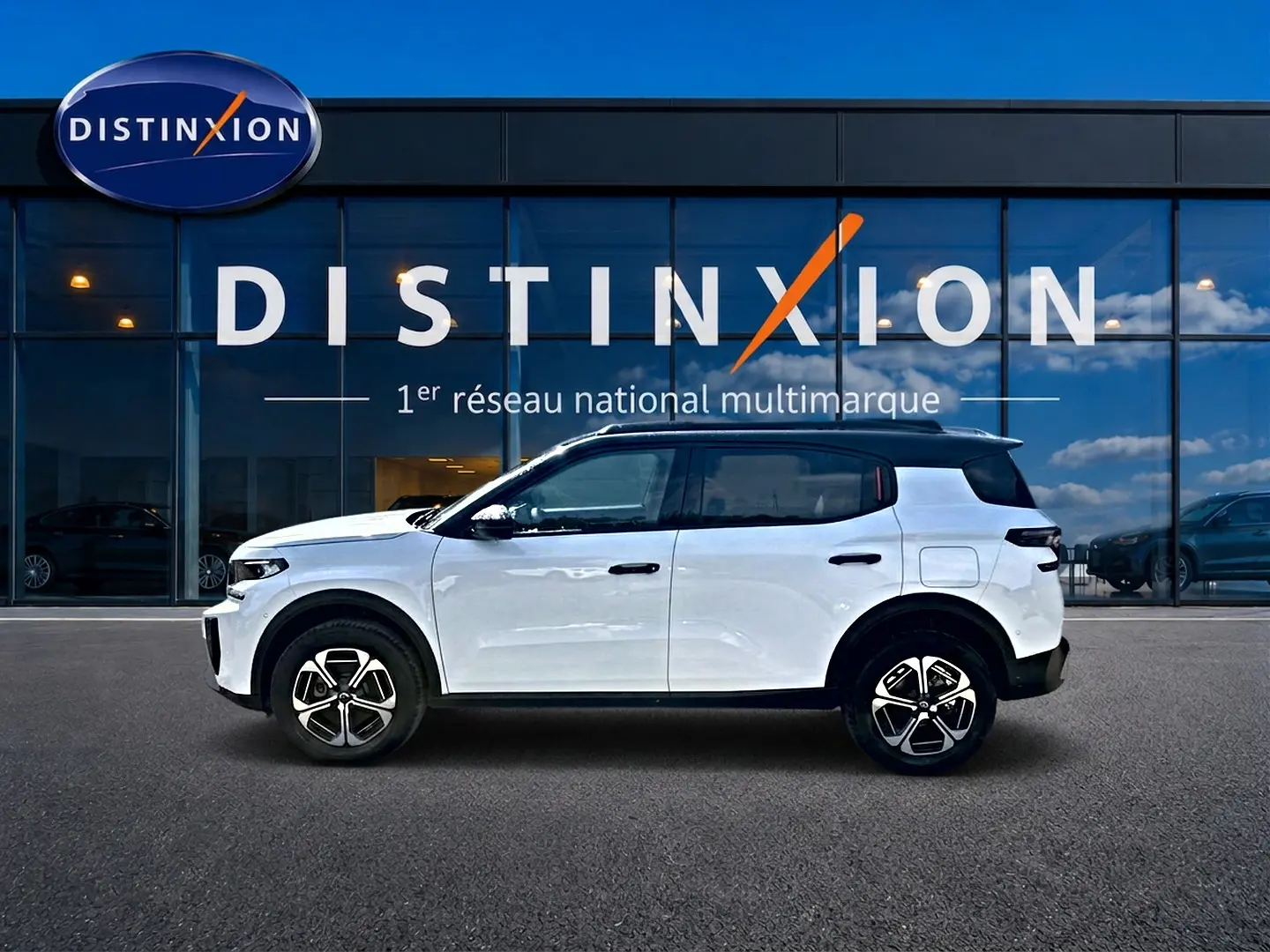 Profil côté gauche d'un Citroën C3 Aircross blanc 2026 avec toit noir, jantes alu et détails noirs contrastants.