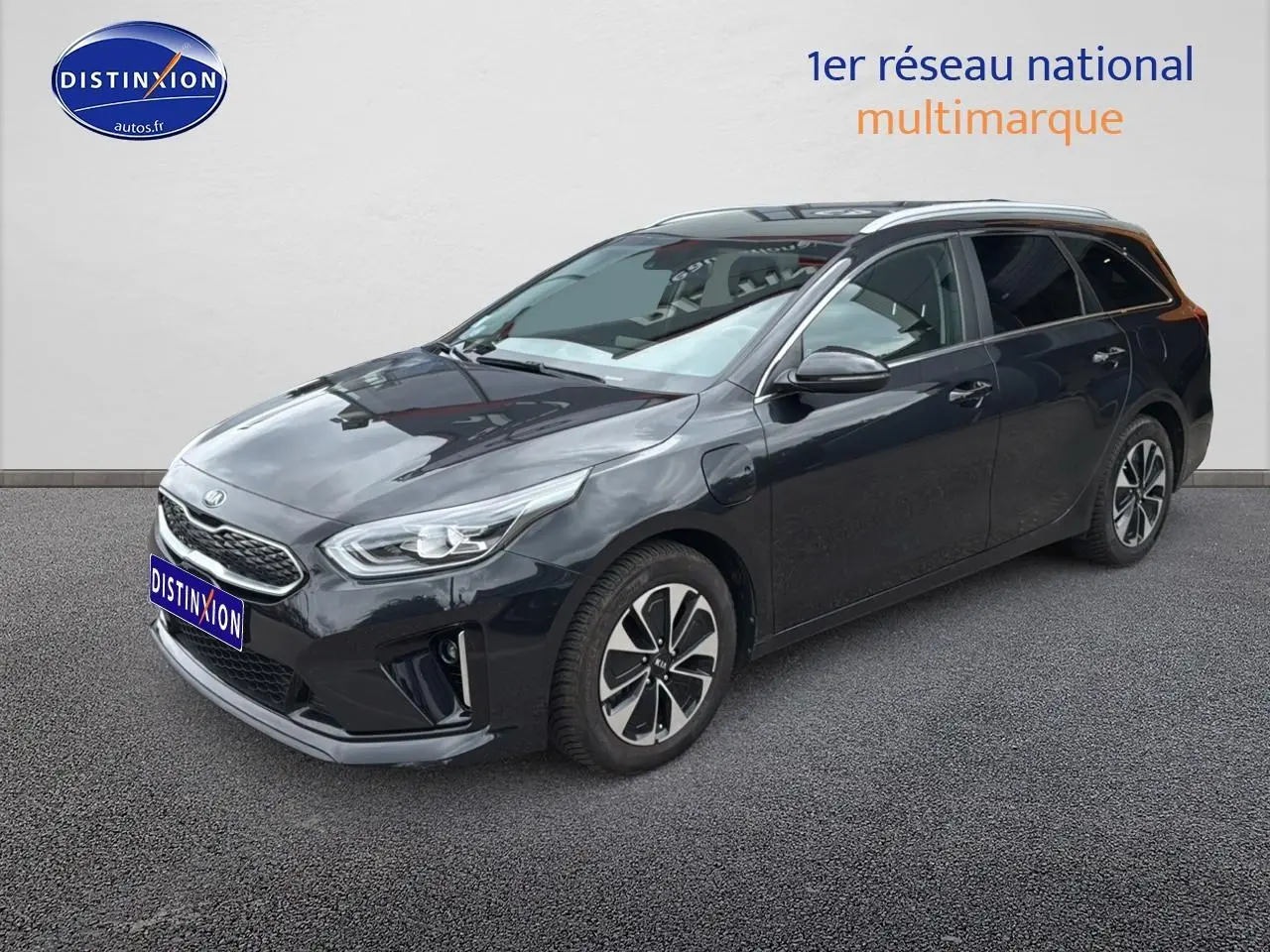 KIA CEE'D SW noire vue 3/4 avant droit, avec jantes alu et barres de toit visibles sur fond neutre.