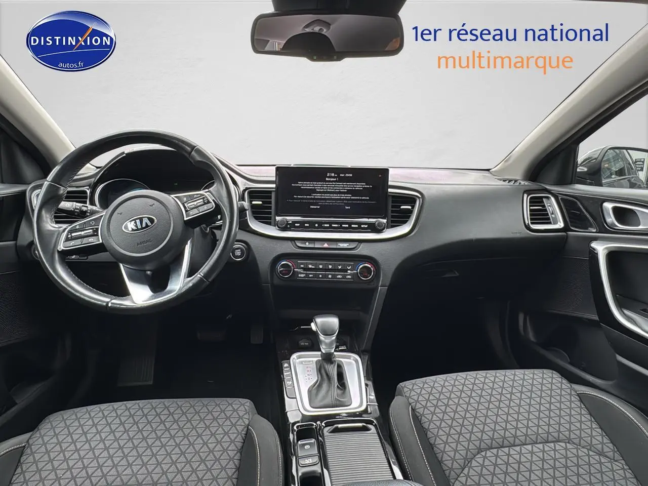 Intérieur noir de la Kia CEE'D SW 2020, vue frontale du tableau de bord avec écran tactile et volant cuir.