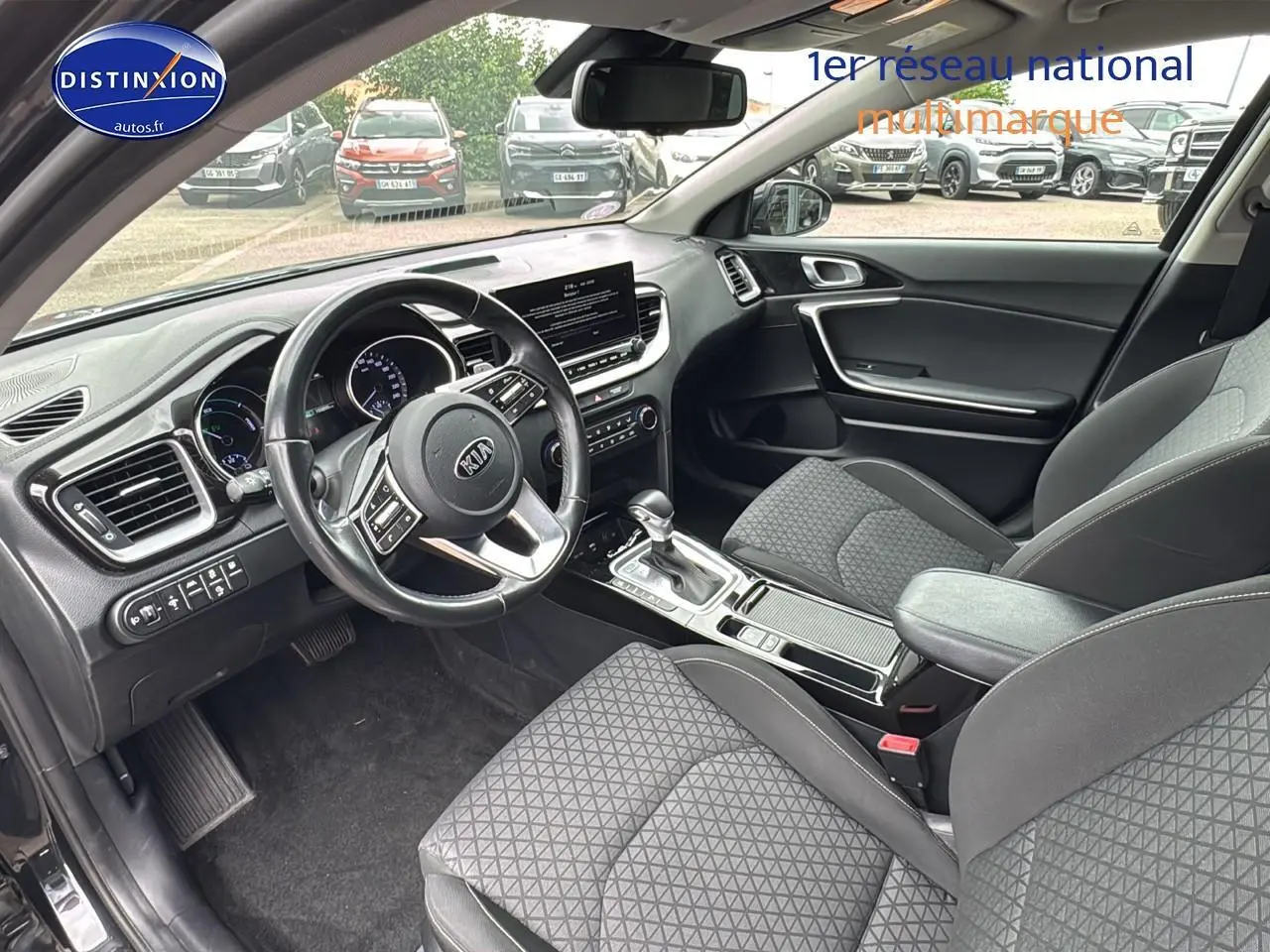 Vue intérieure côté conducteur de la Kia CEE'D SW noire 2020 avec volant cuir et console centrale moderne.