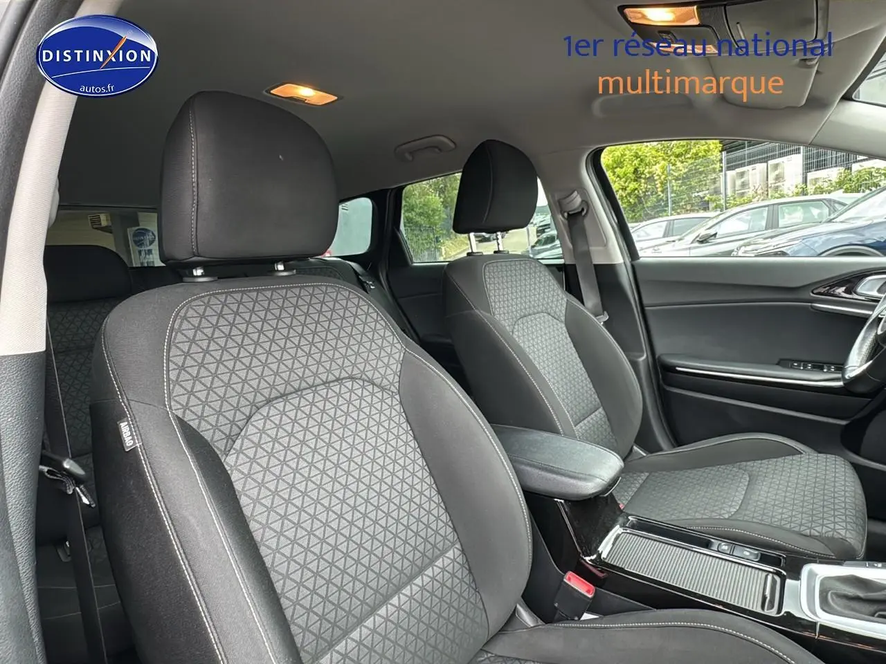 Intérieur de la KIA CEE'D SW 2020, vue côté droit sur sièges tissu noir et accoudoir central avec rangement.