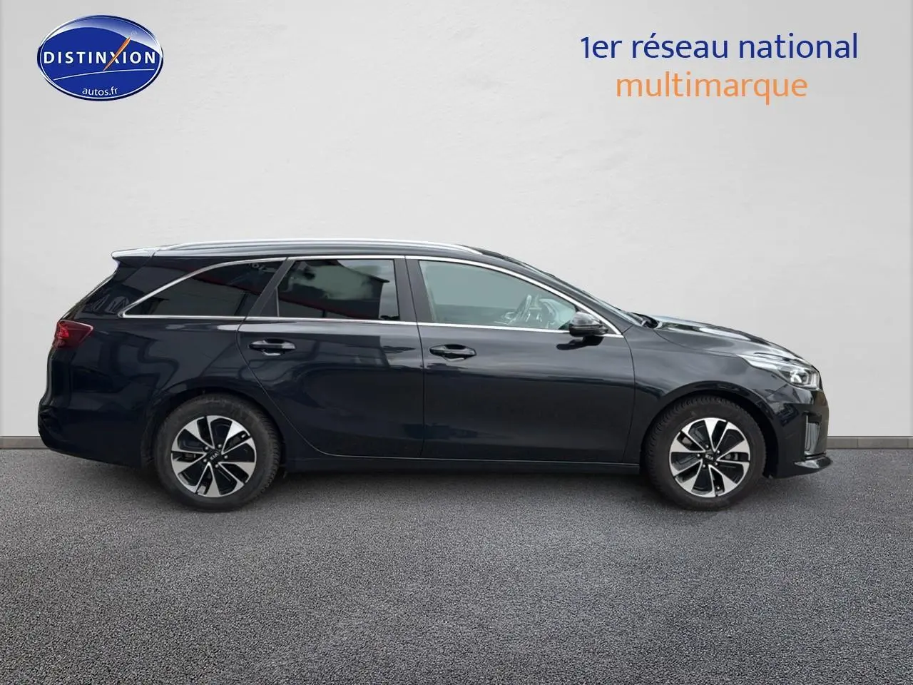 Profil côté droit d'une Kia CEE'D SW noire 2020 avec jantes alliage et barres de toit visibles.